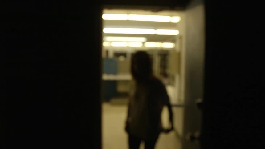 Woman stands in a doorway of a large brightly lit room