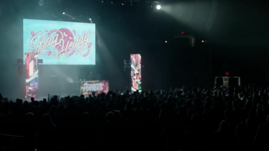 A dj is playing for a large audience
