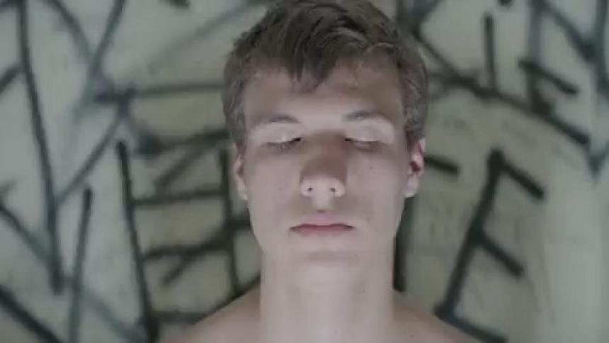 A man is sitting in a dark room with a strobe light flashing