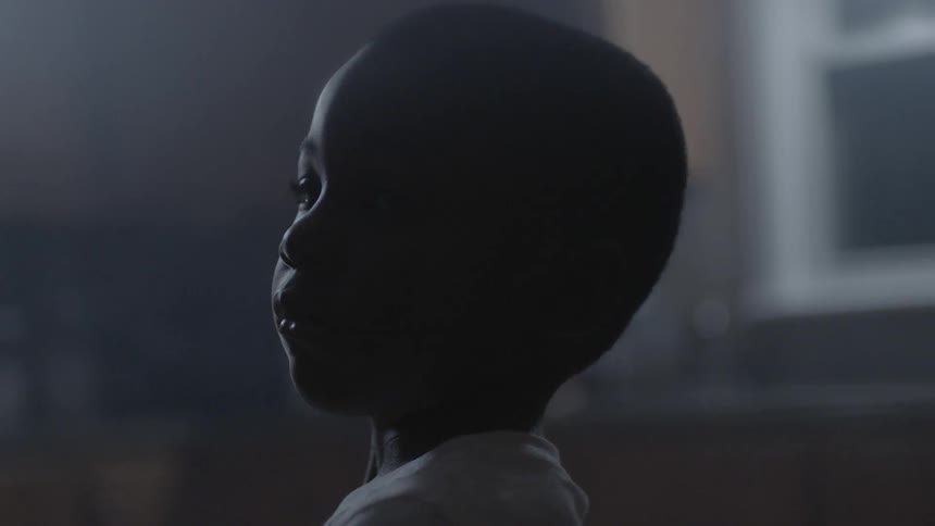 A boy listens to his surroundings as he stands in kitchen at night