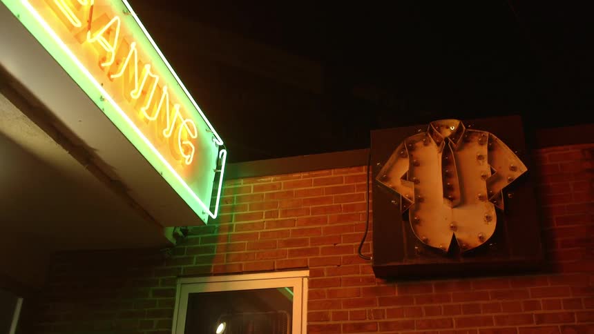 Neon lights illuminate outside a shop