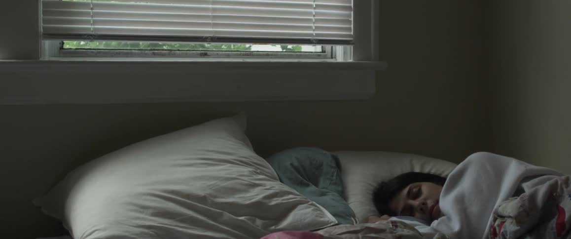 A woman is laying in bed trying to go to sleep