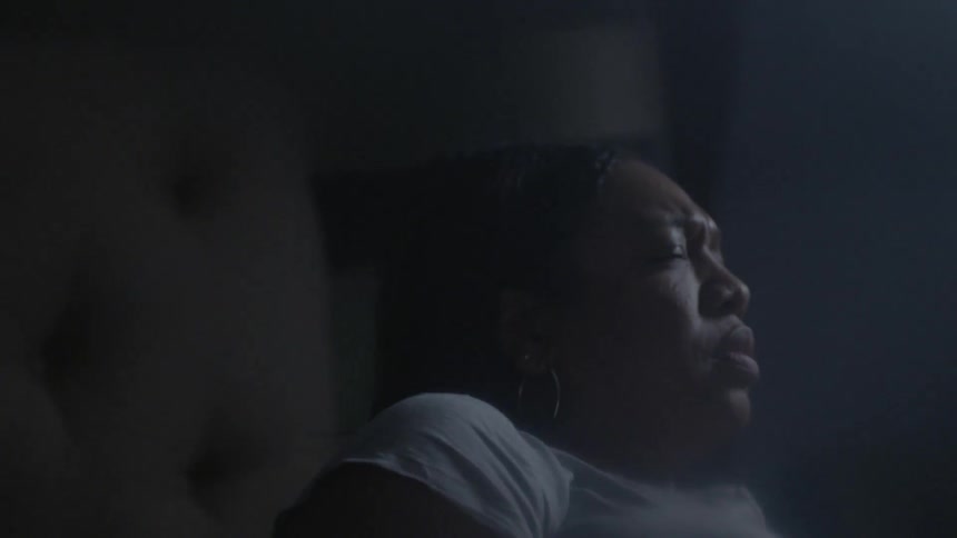 A woman wakes up and gets out of bed