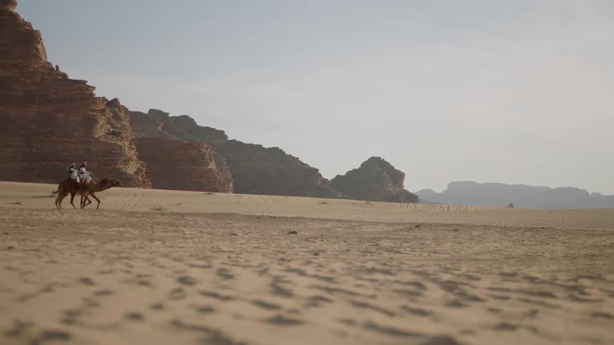 People riding camels in the desert