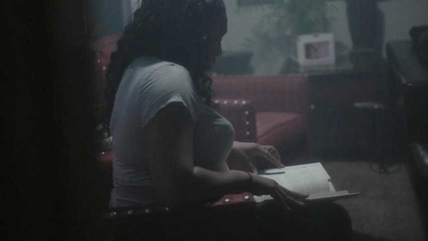 A woman is sitting in the living room reading