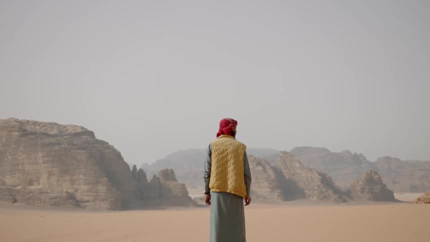 An arab man stands in the desert