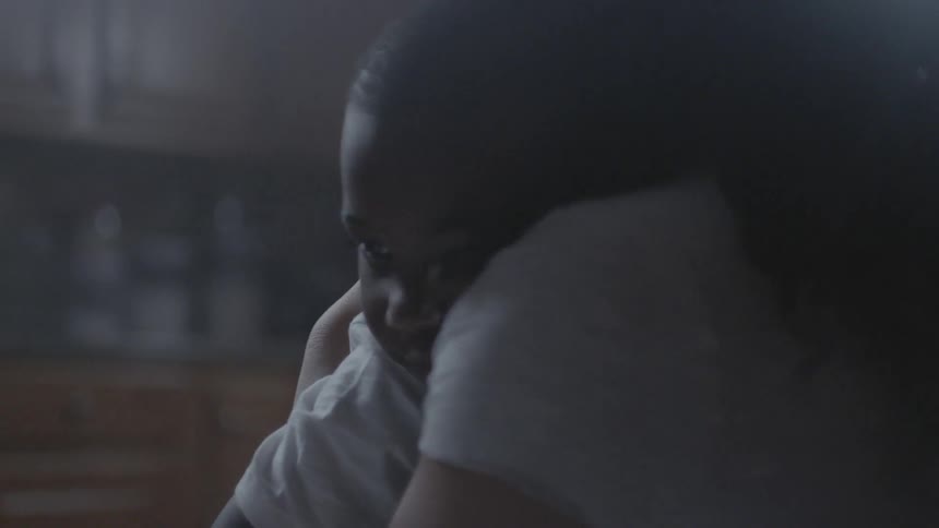 A mother hugs her child in the kitchen