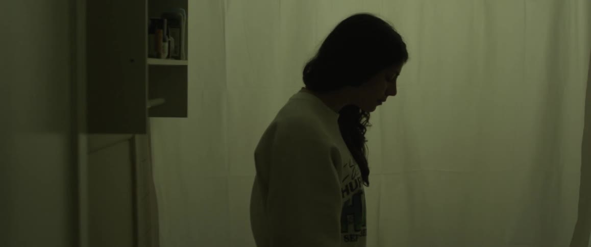 A girl is standing in the bathroom looking at something off camera