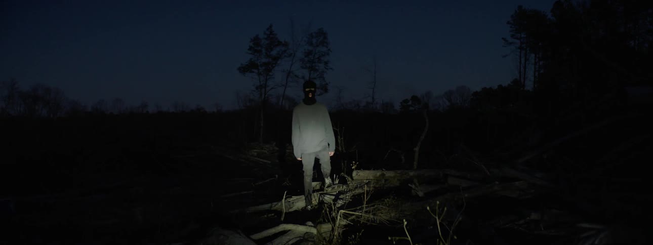 A light flashes on a man in a mask