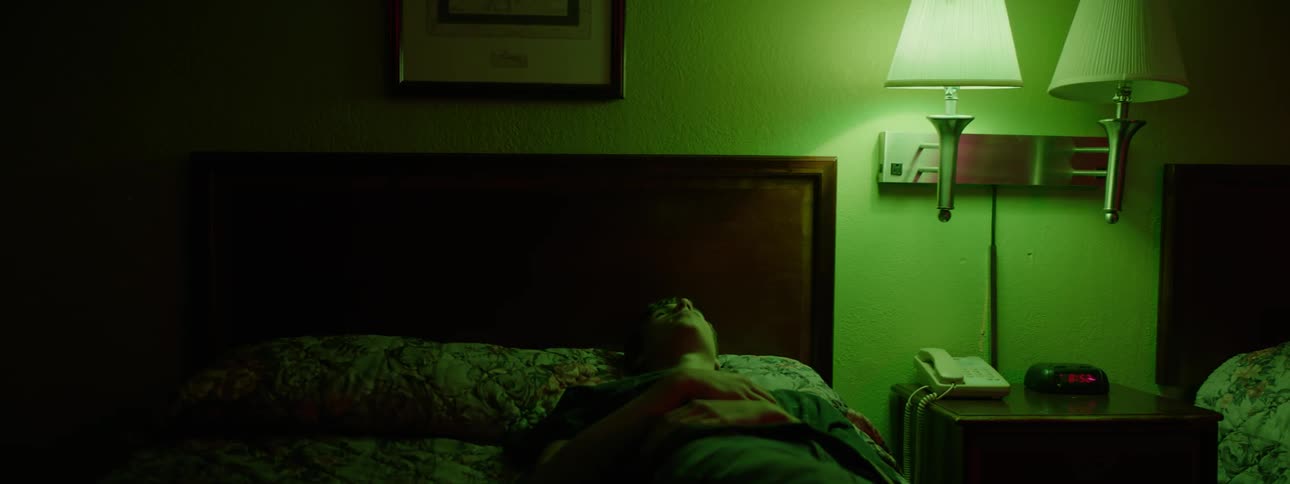 A man lays on a hotel bed