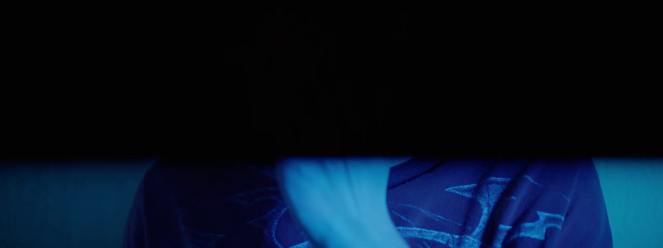 A man aims a gun in a room with flashing lights