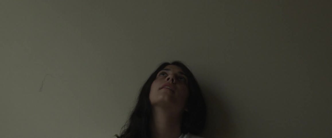 A dark-haired woman looks up