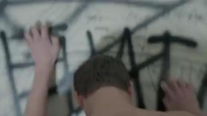A man claws at a wall