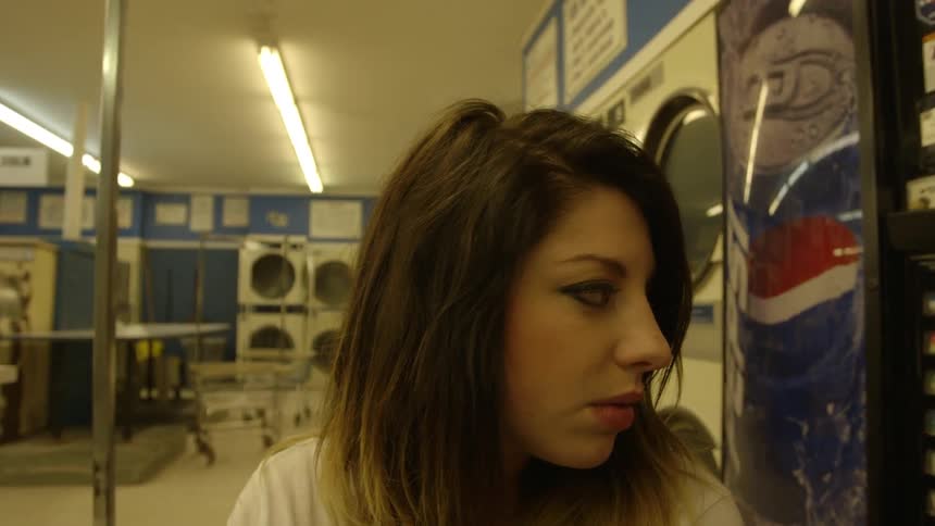 A woman walks through a laundromat