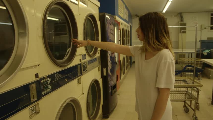 A woman points towards a washing machine