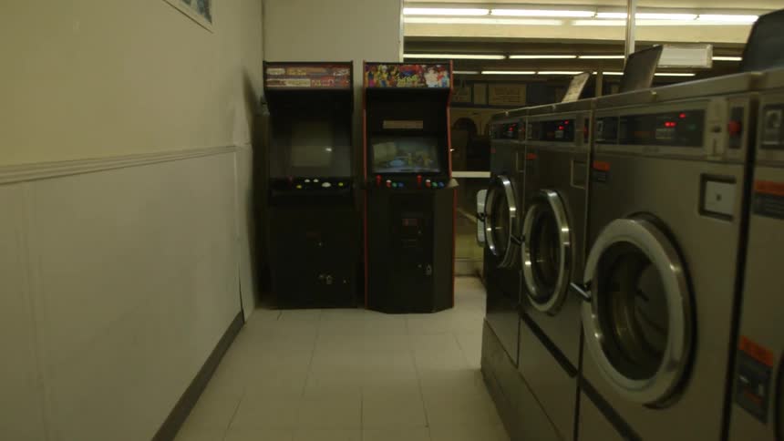 An arcade machine in a laundromat flashes images