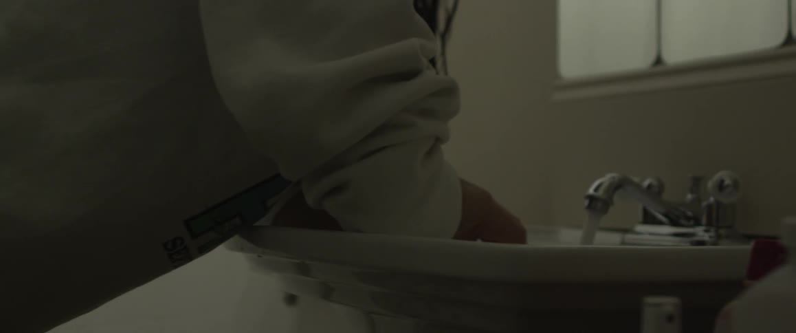 A woman stands at a bathroom sink