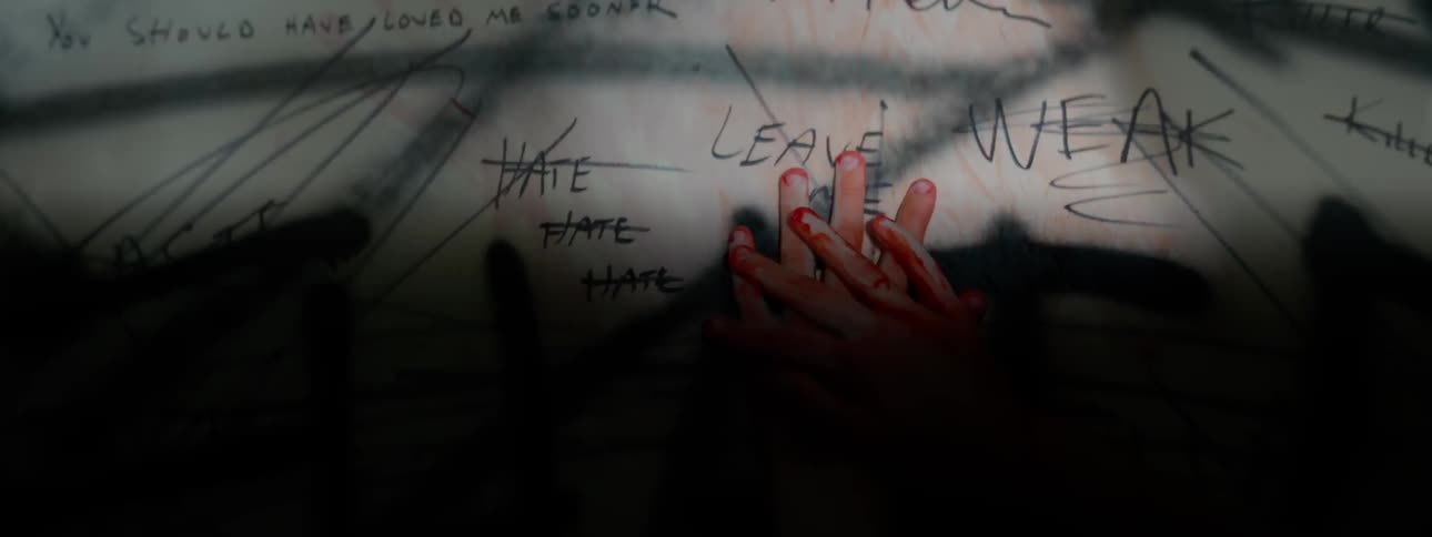 Hands with red paint on them move over a drawing
