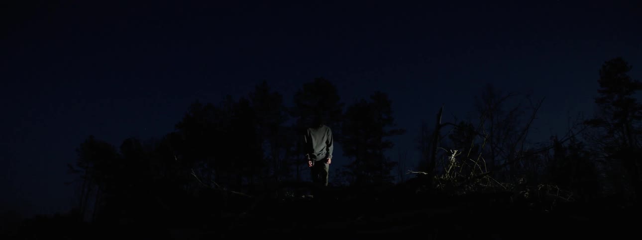 A strobe light flashes on a masked man