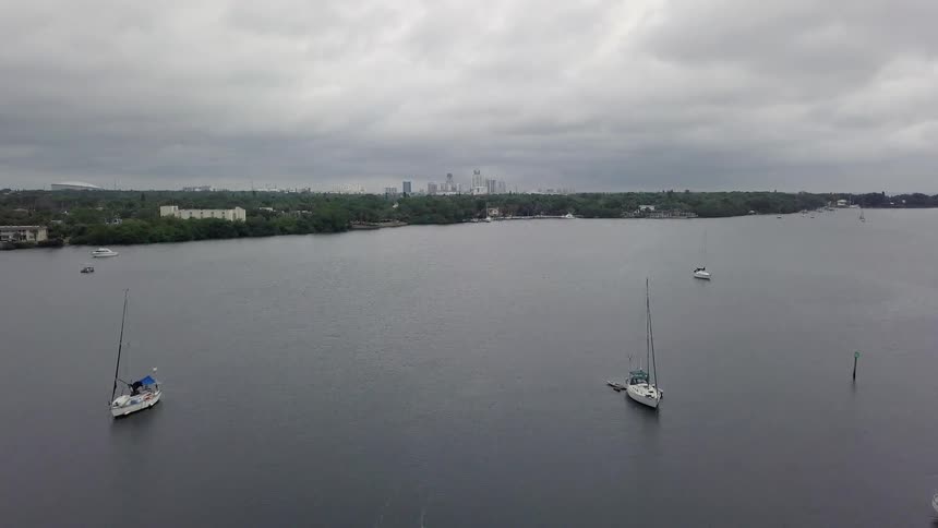 Boats sail on a lake on a cloudy day