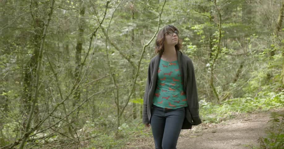 A woman is hiking through the forest