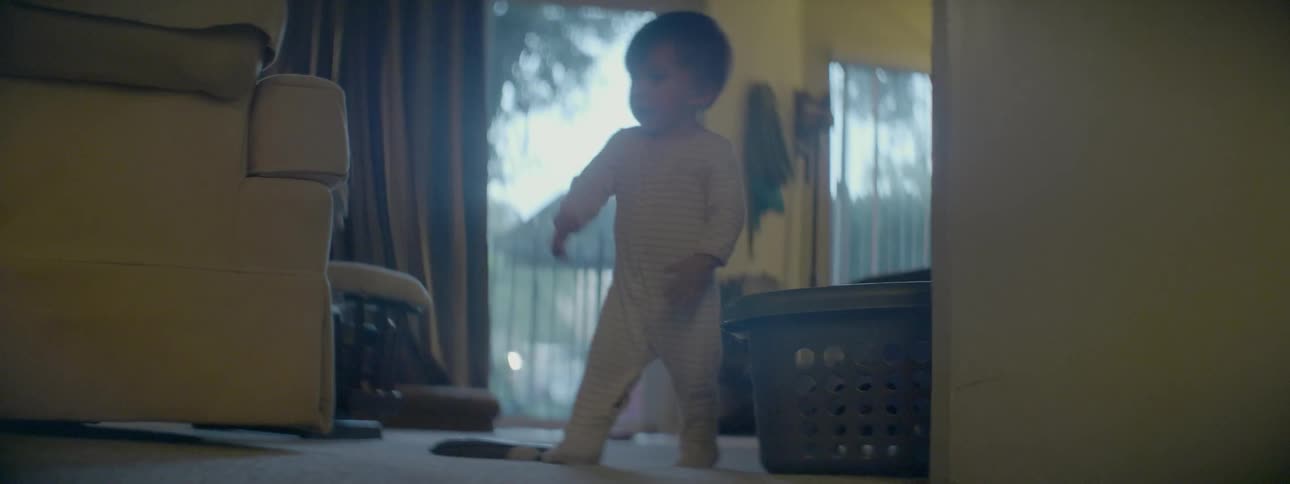 A baby walks around on the carpet