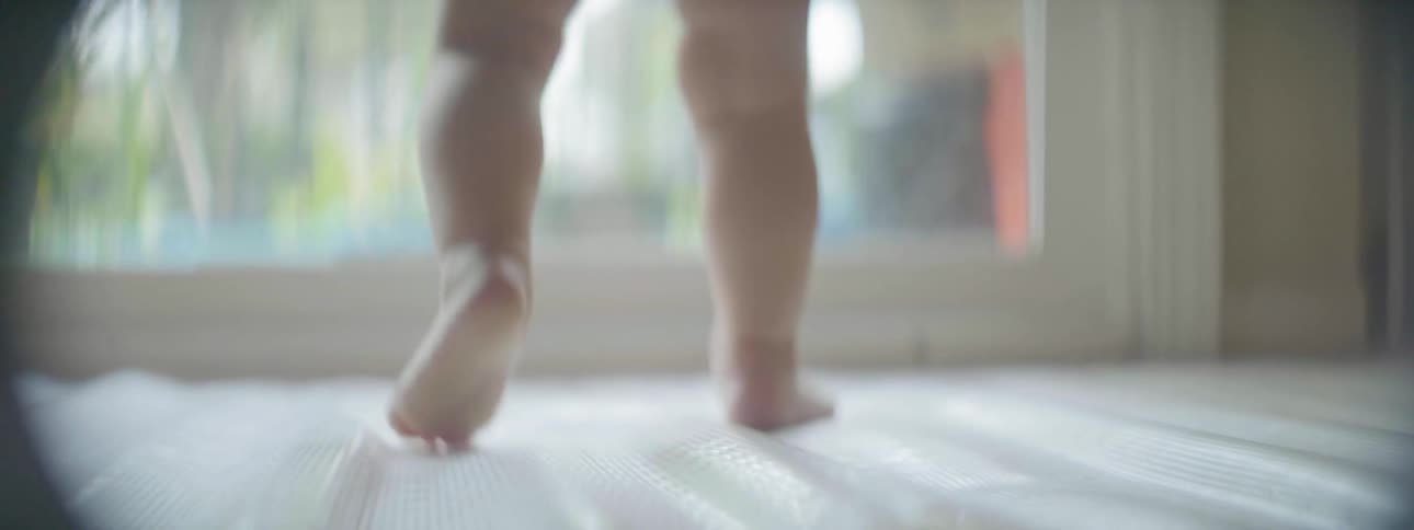 A baby walks on the carpet