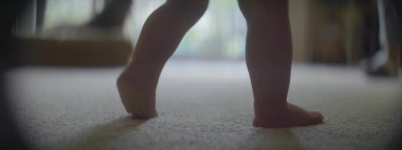 A baby slowly walks on the carpet