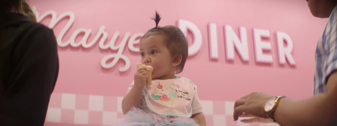 A baby is eating an ice cream cone and drops it