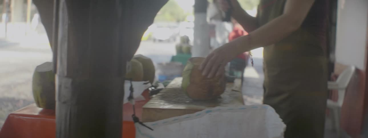 Someone is preparing a coconut to be ate