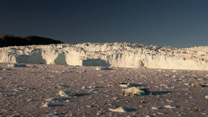 A glacier looms over an ice field