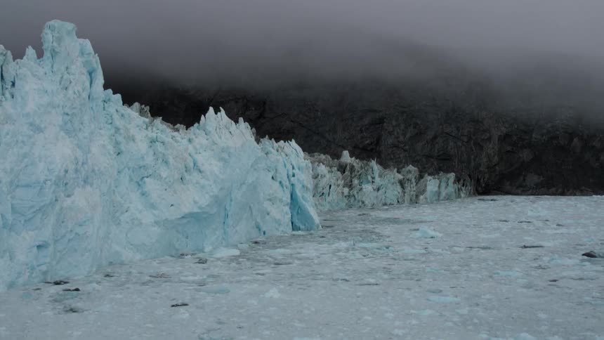 The water is frozen with a ice wall lining the shore