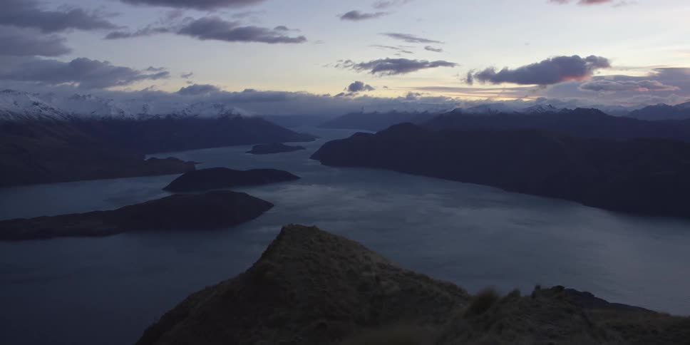 Islands dot a large lake near a mountain range