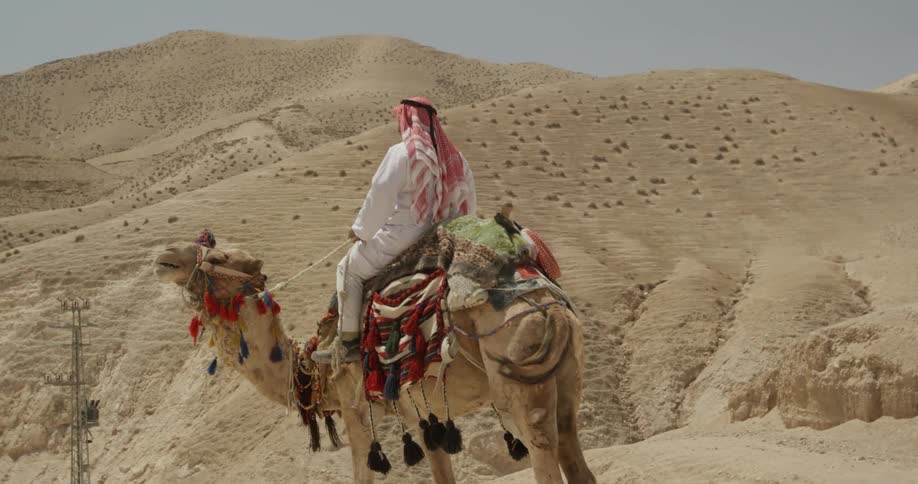 A person is riding a camel in the desert