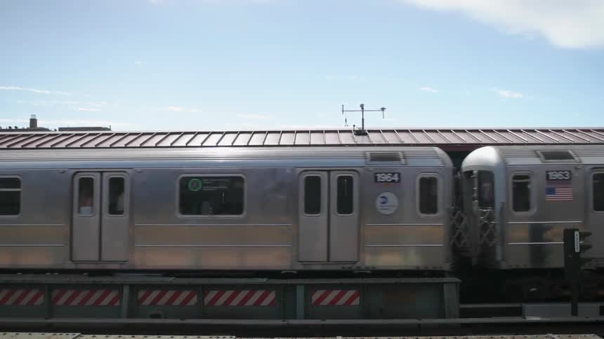 Train passing by a depot on a sunny day