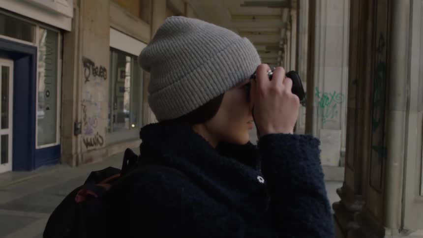 A woman takes a photograph with a camera