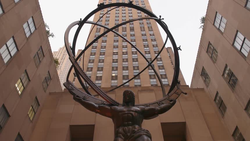 A large atlas statue sits in front of this building