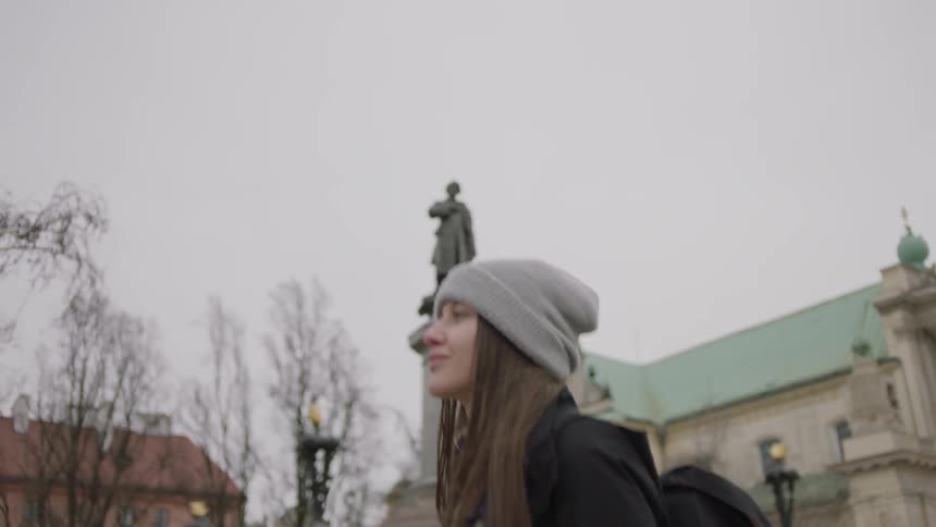 Woman walking near buildings on a cloudy day