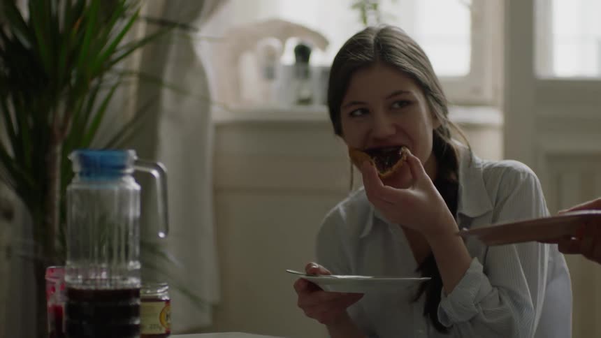 A woman eats toast  covered in jam