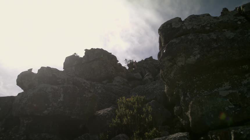 Clouds passing over a cliff on a sunny day