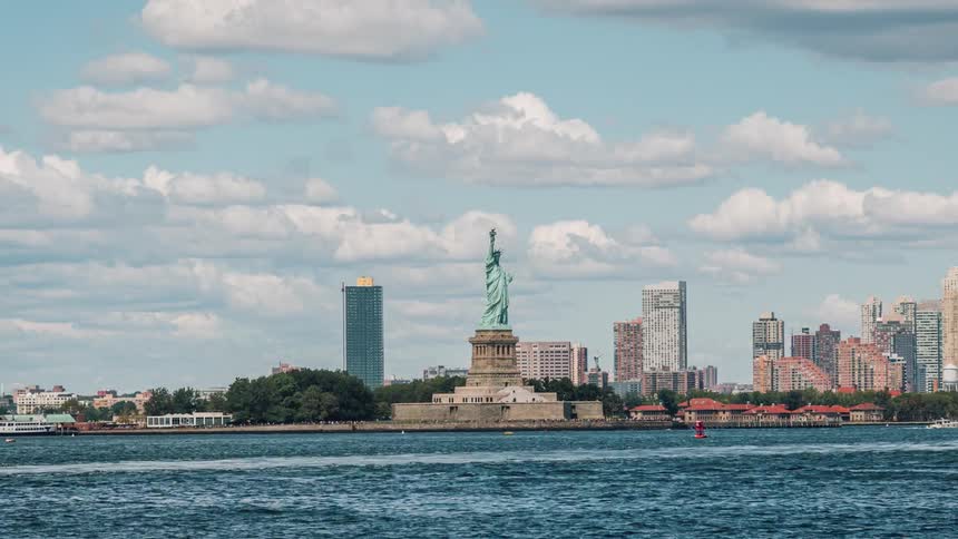 The statue of liberty is right before the city ahead