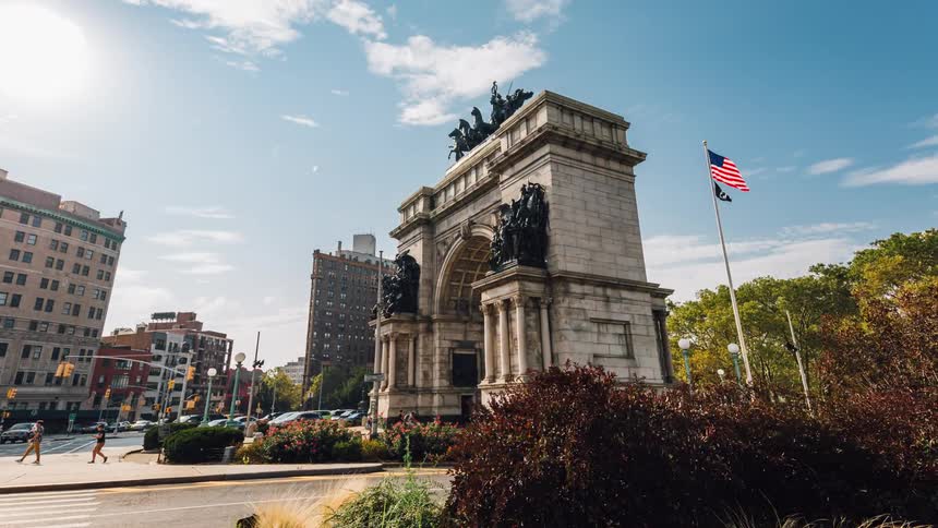 People commute near a monument in a city