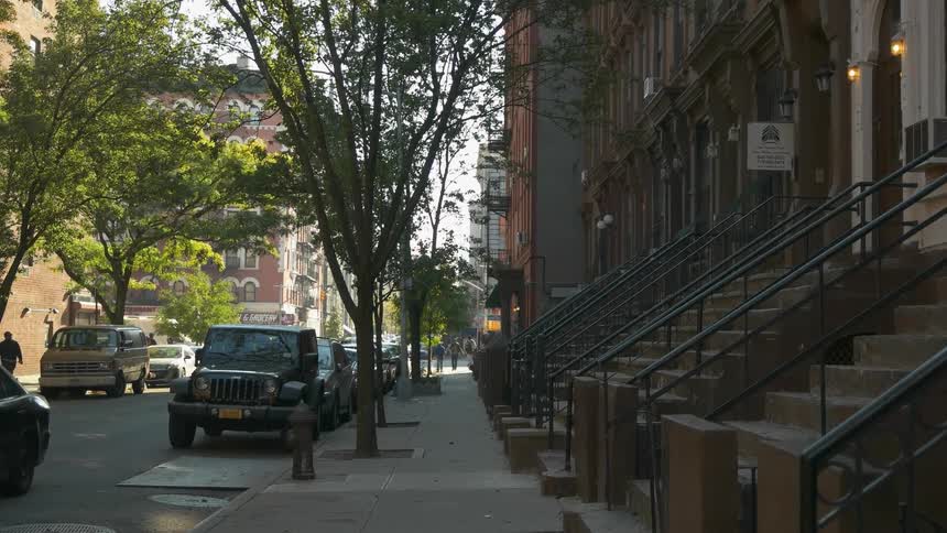 Vehicles parked on the street lined with buildings