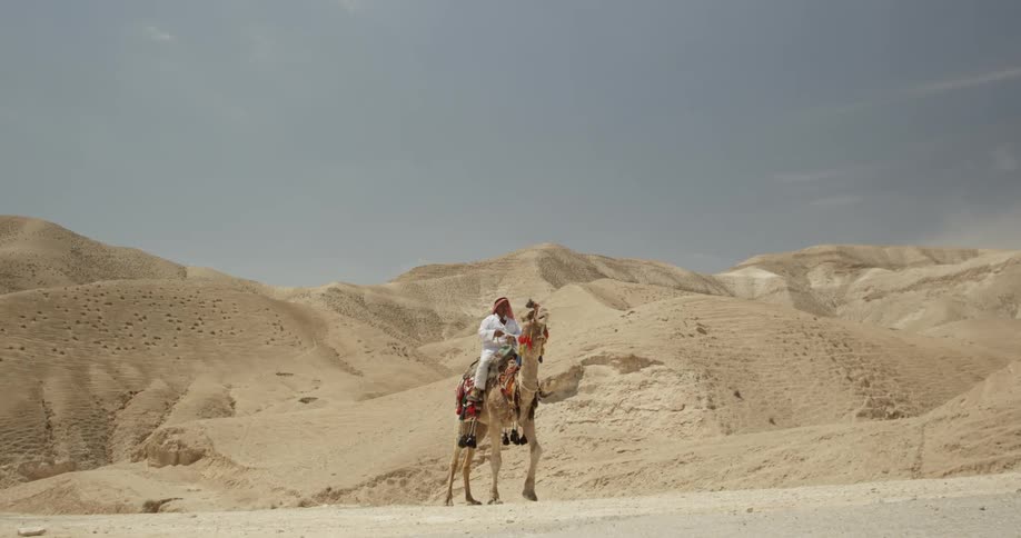 A man rides a camel in the desert