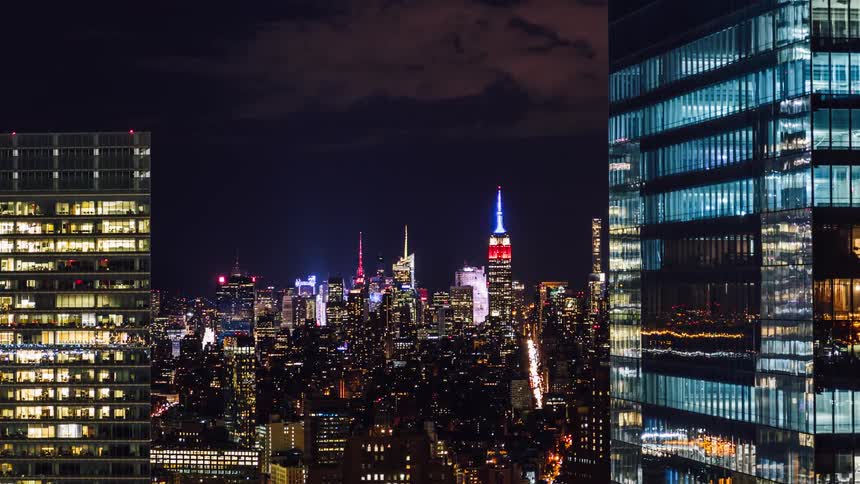 Illuminated buildings sit under a dark sky at night