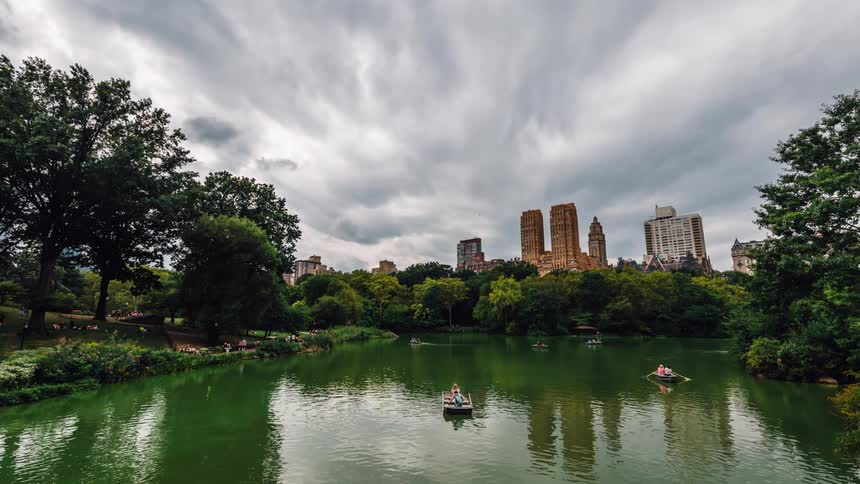 Boats floating down a green river on a cloudy day