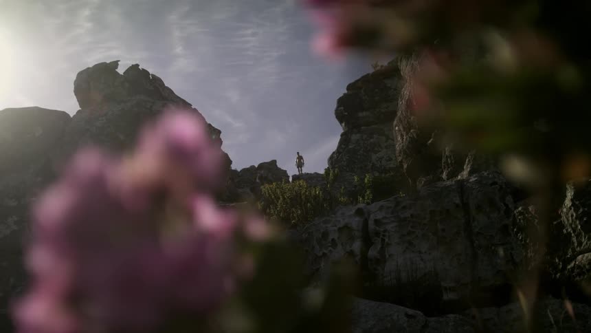 A man is hiking up the mountain in the distance