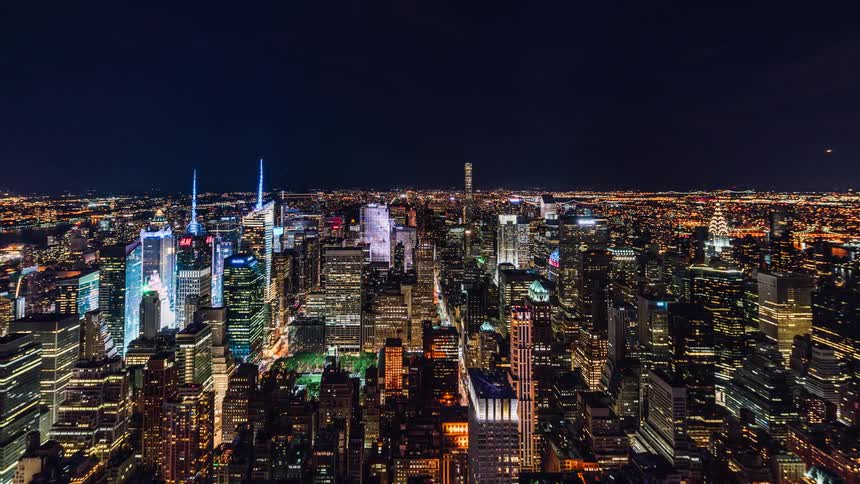 Traffic moves through a city as the lights shimmer at night