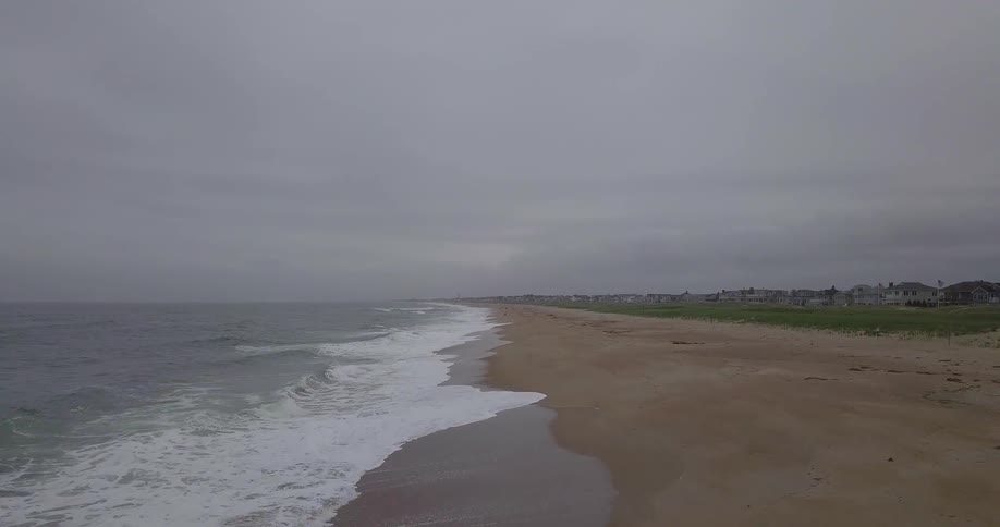 Waves roll onto a beach on a cloudy day