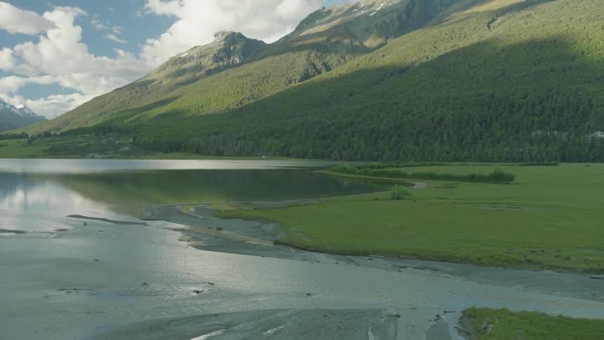 A lake at the base of a forested mountain